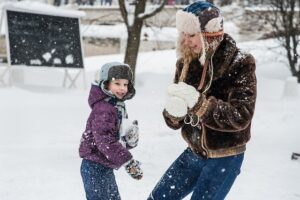 コートを着た大人と子供と雪