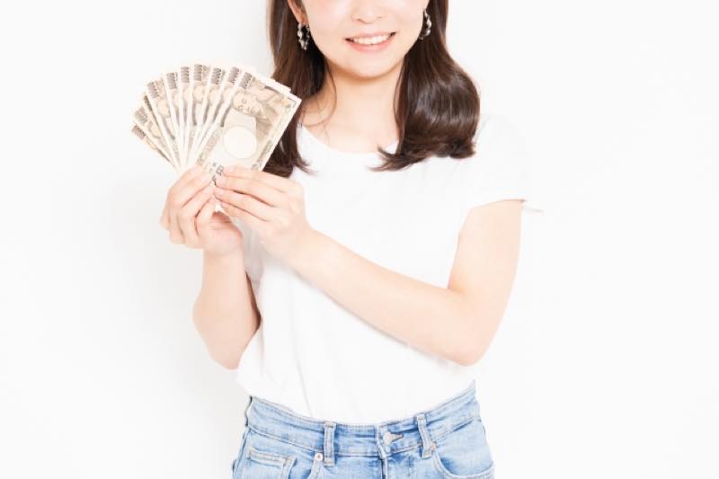 現金を手にして喜ぶ女性