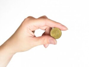 コインを持つ手・コインの価値を考えるイメージ